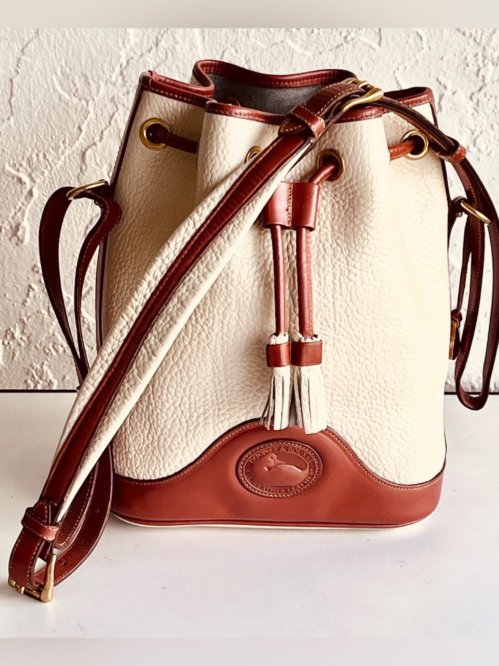 VINTAGE DOONEY AND BOURKE CREAM AND TAN LEATHER SHOULDER BUCKET